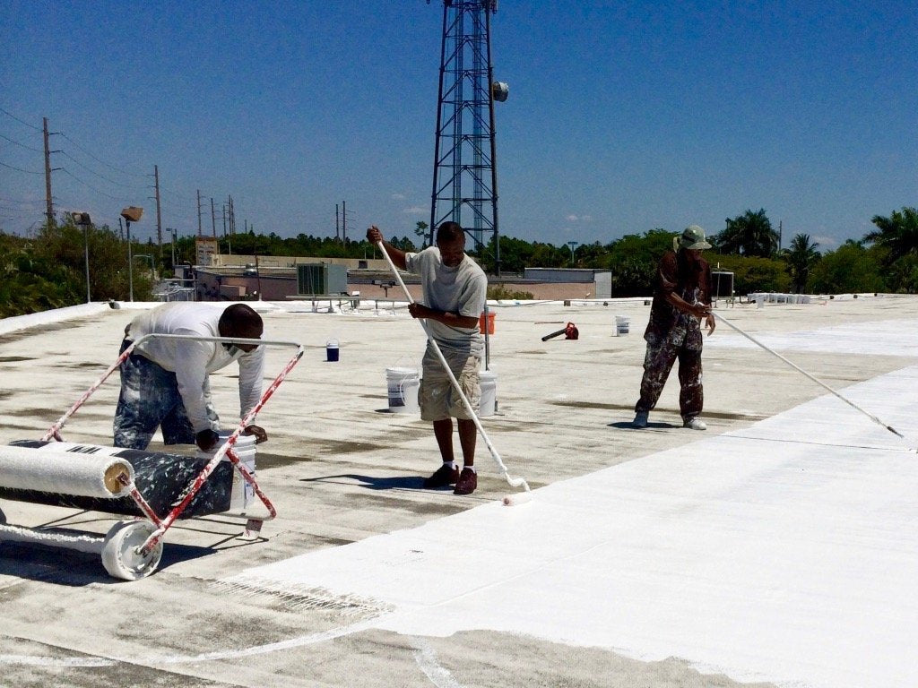 modified bitumen roof being coated with Lexis silicone coating.